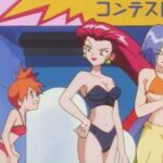 An anime woman with orange hair staring at an anime woman with long maroon hair in a purple bikini and a short haired anime man with large breasts in an orange bikini in Pokémon.
