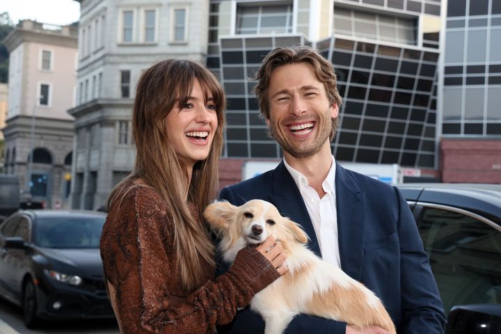 “Twisters” co-stars Daisy Edgar-Jones, left, and Glen Powell pose with Powell’s dog, Brisket.