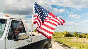 American flag flying behind a pickup truck