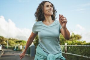 A smiling woman goes for a walk in the sunshine.