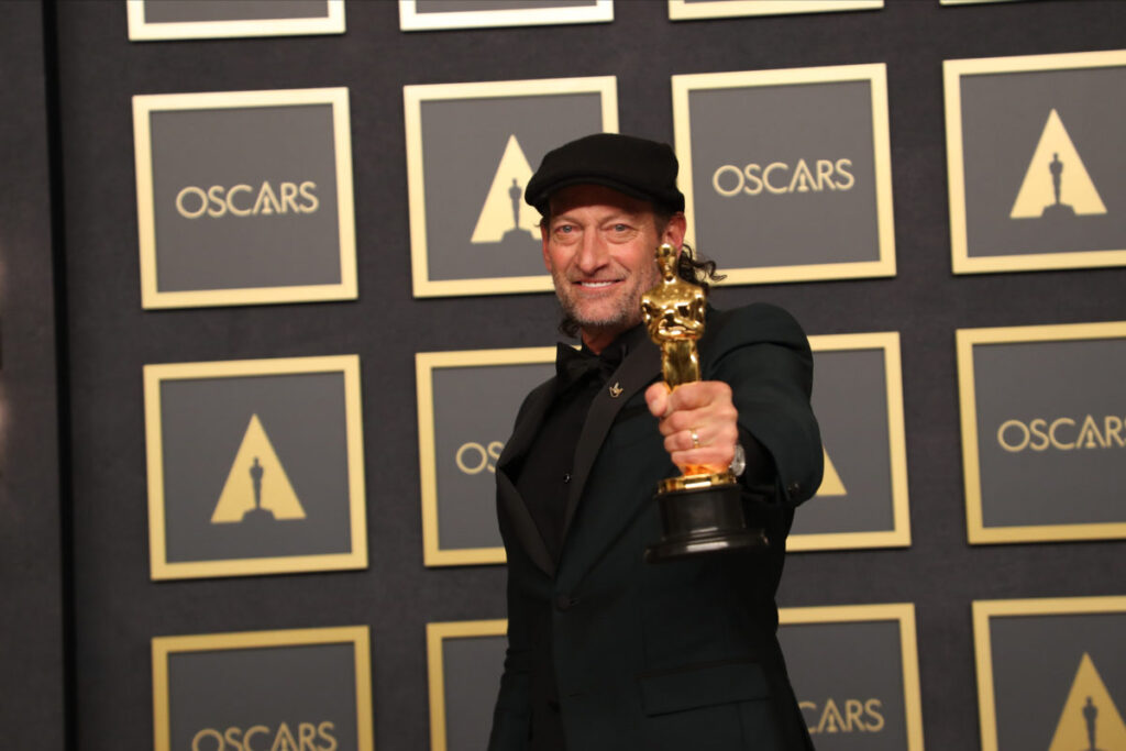 Troy Kotsur holding his Academy Award, which he won for his performance in 'CODA'