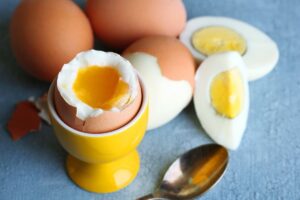 Boiled eggs on table, eggs next to spoon.