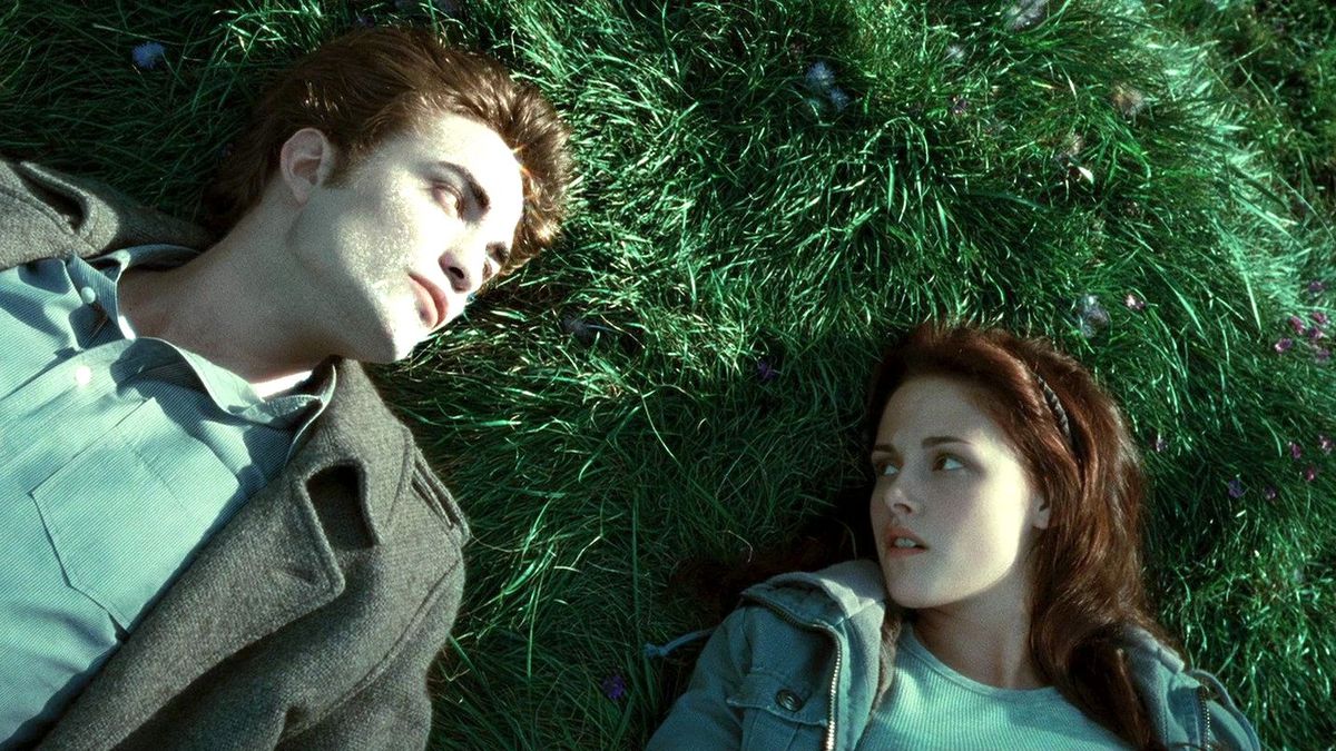 Robert Pattinson and Kristen Stewart lie in grass in Twilight.