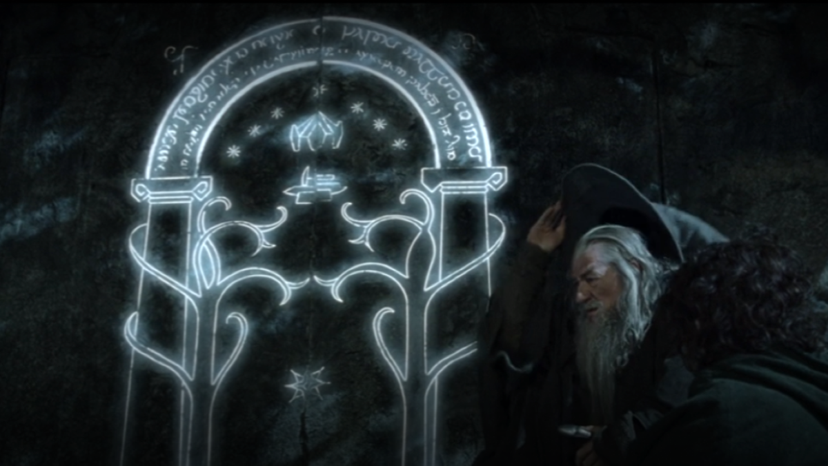 Gandalf and Frodo sit in front of the west gate to Moria in Fellowship of the Ring