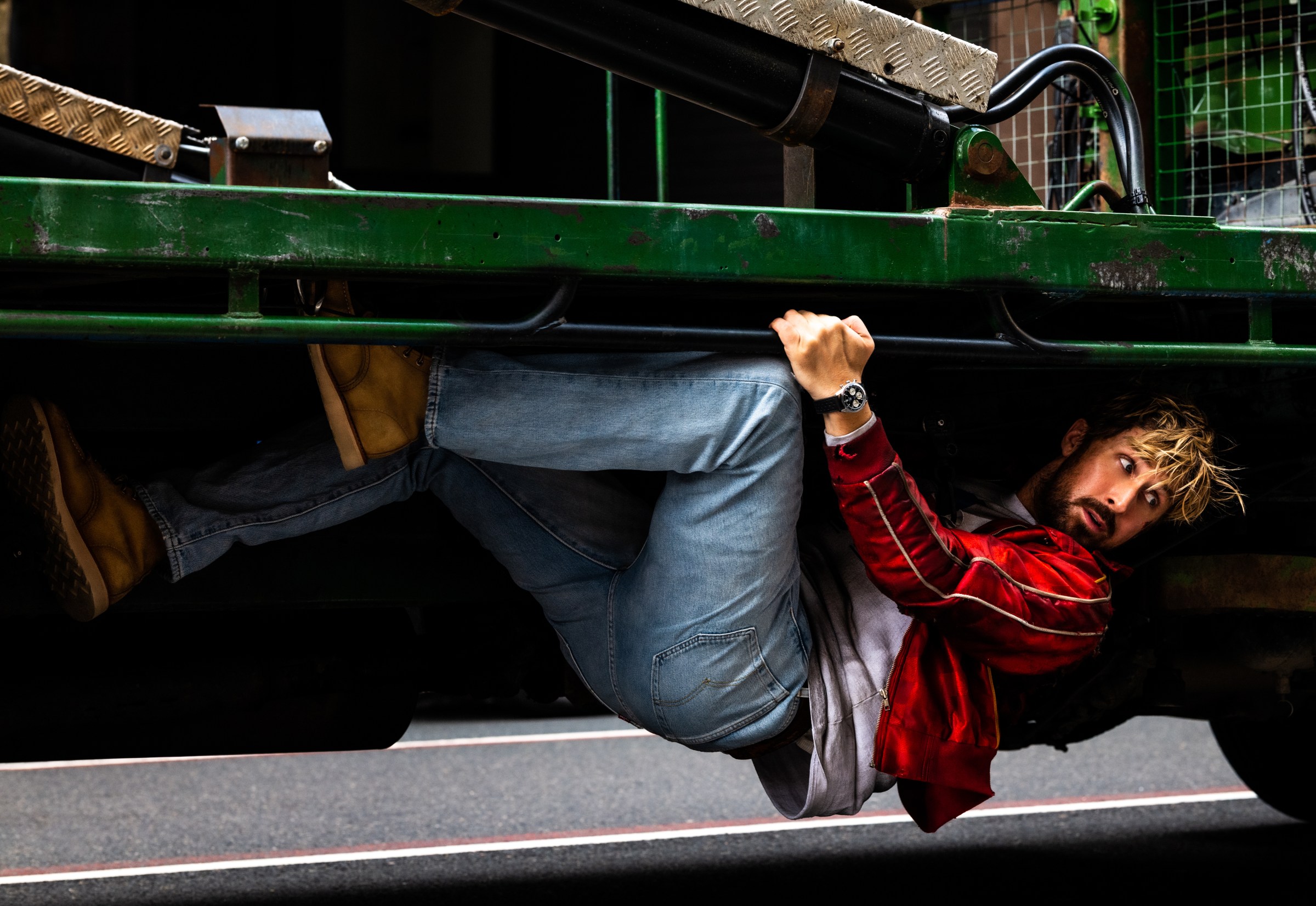 Ryan Gosling hangs onto the bottom of a garbage truck in The Fall Guy