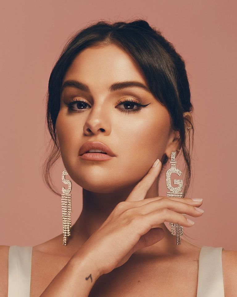 Selena Gomez advertising Rare Beauty products on her face