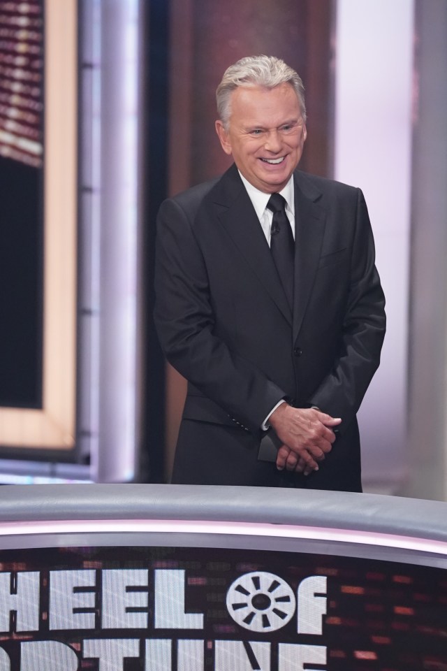 Pat Sajak stands before the wheel during an episode of Celebrity Wheel of Fortune