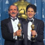 Two men holding statuettes