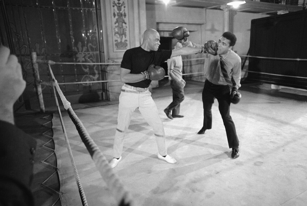 Muhammad Ali, right, allows himself to be tagged with a left thrown by actor James Earl Jones.