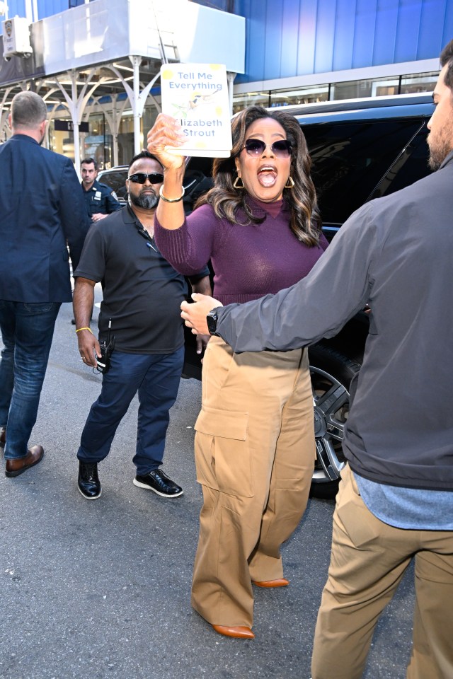 Oprah Winfrey holding Elizabeth Strout's book Tell Me Everything outside the Good Morning America studios in New York City