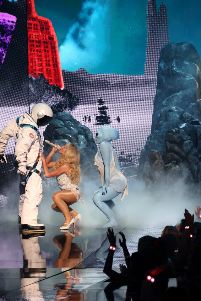 Sabrina dirty dancing on an astronaut as an alien twerks behind her at the VMAs