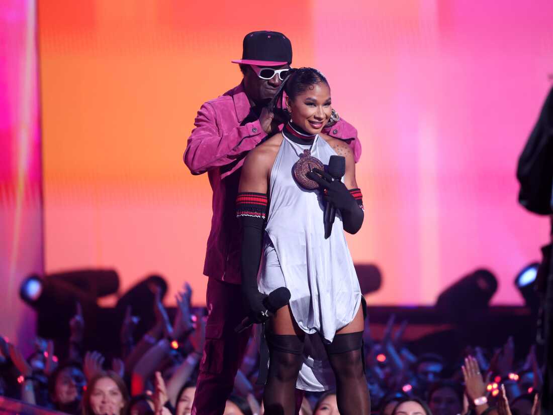 Flavor Flav gives gymnast Jordan Chiles a bronze clock during the VMAs.