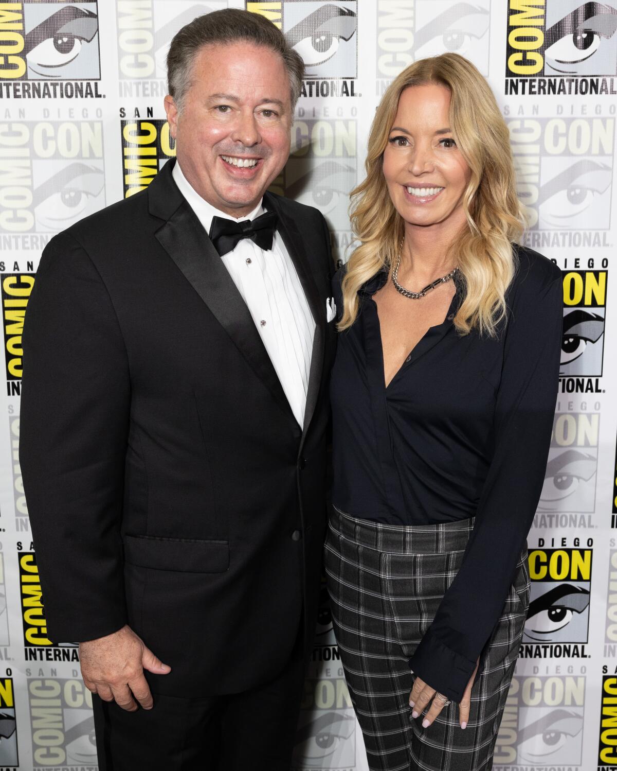 Women of Wrestling co-owners David McLane and Jeanie Buss posing for photos at the 2024 San Diego Comic-Con