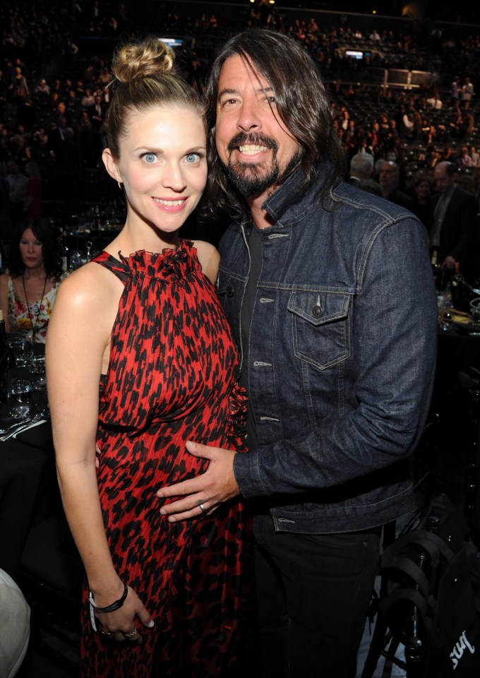 Dave Grohl places his hand on wife Jordyn Blum's baby bump during the 29th Annual Rock and Roll Hall of Fame Induction Ceremony on April 10, 2014