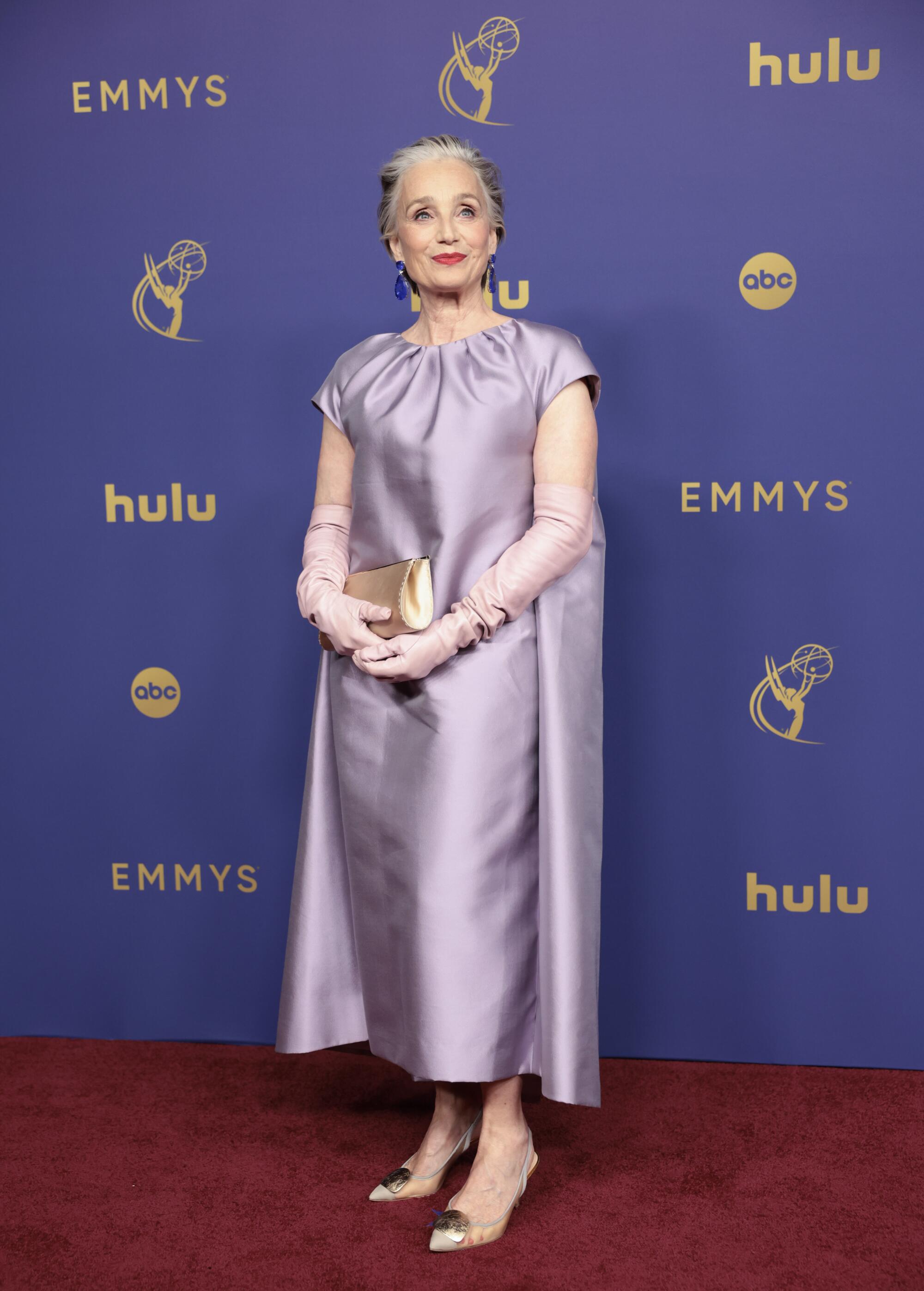 Kristin Scott Thomas wears a light purple caped dress.