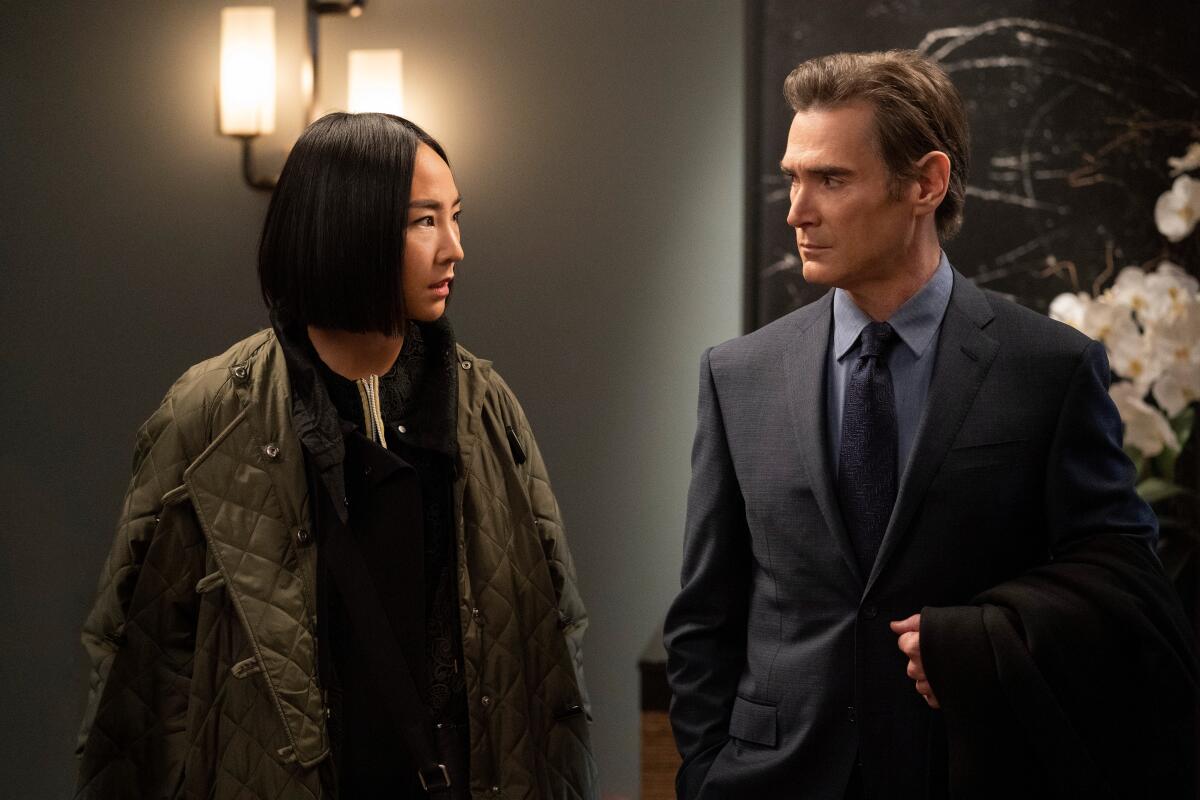 Greta Lee, in an olive green bomber jacket, and Billy Crudup, in a suit and tie, in "The Morning Show." 