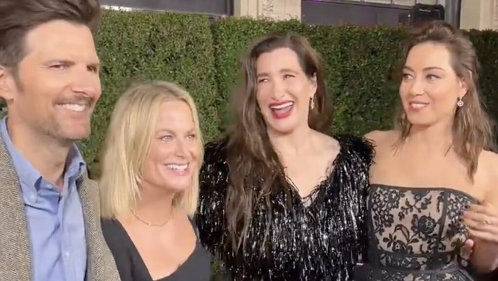 Parks & Rec's Adam Scott, Amy Poehler, Kathryn Hahn, and Aubrey Plaza smiling together on the red carpet of Agatha All Along