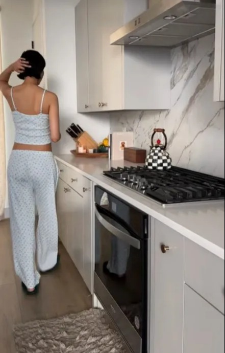 The kitchen features white countertops and gray cabinets with a marble backsplash