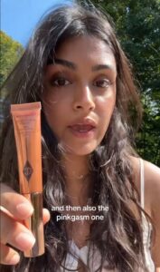 A TikToker holding up a tube of Charlotte Tilbury Light Wands