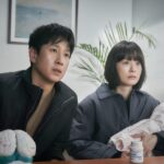 Soo-jin (Jung Yu-mi) and Hyun-su (Lee Sun-kyun) sit in a sleep doctor’s office, while Soo-jin holds a wrapped-up baby