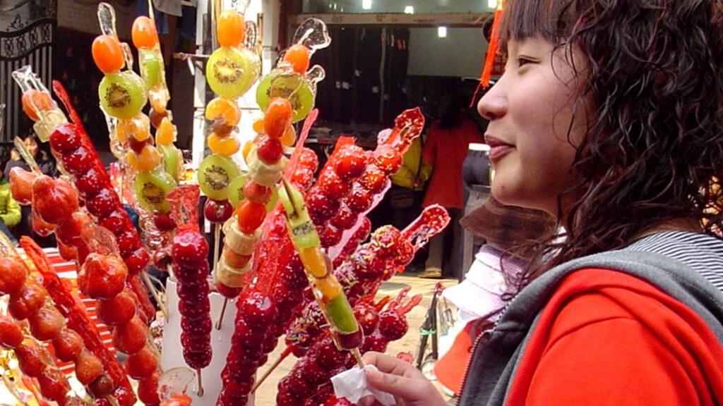 woman buying tanghulu from a market