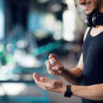 A man using hand sanitizer at the gym