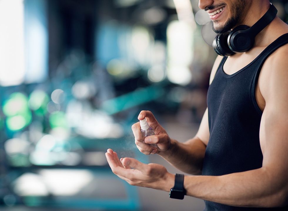 A man using hand sanitizer at the gym