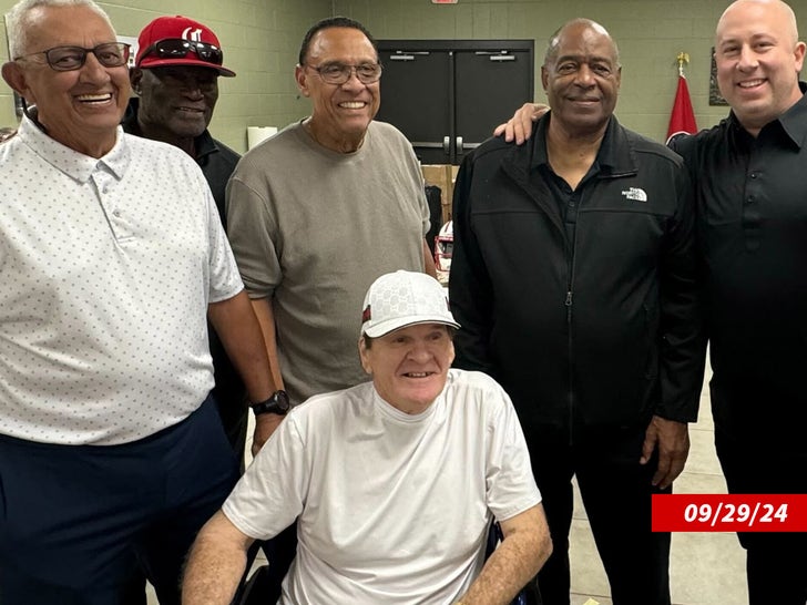 Picture taken on September 29, 2024 of Pete Rose sitting while wearing a white hat and white t-shirt, in front of  Dave Concepcion, George Foster, Tony Perez, Ken Griffey Sr., and a fifth person.