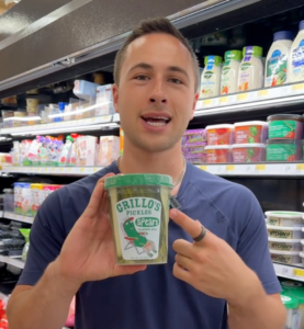 Young man in a navy blue shirt holding up snacks at a Target store