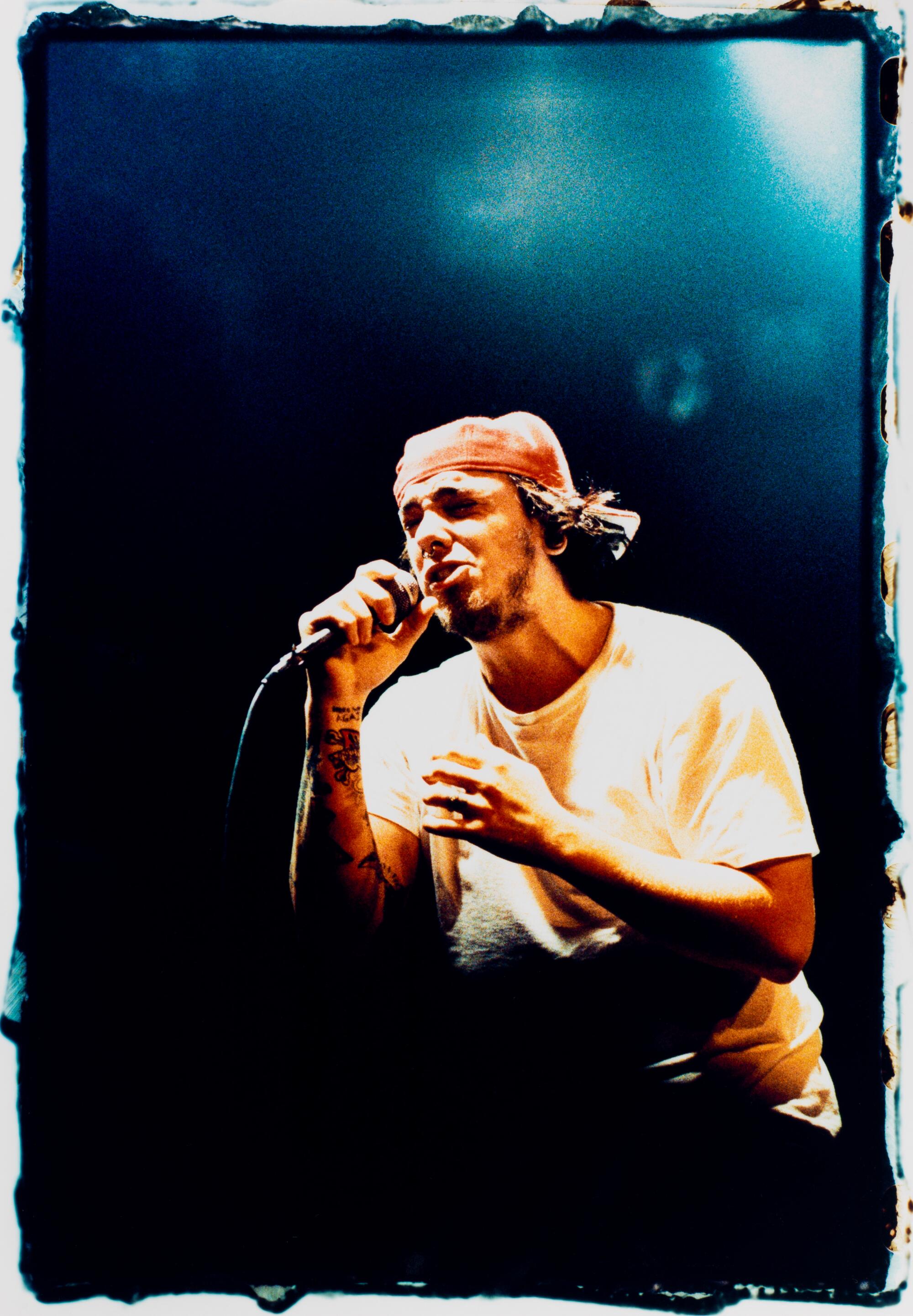 J Navarro of Suicide Machines wears a backwards red cap and sings into a microphone.