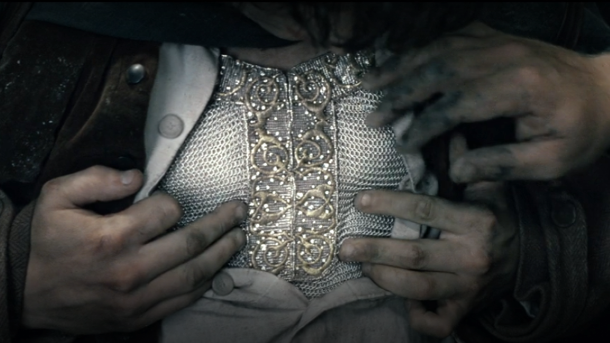 Frodo reveals his mithril shirt by opening the buttons of his cloth shirt in The Fellowship of the Ring