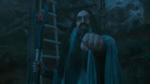 Ciarán Hinds as the Dark Wizard with his hand out holding his staff in the other on The Rings of Power