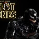 Venom holding a chicken wing on Hot Ones