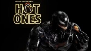 Venom holding a chicken wing on Hot Ones