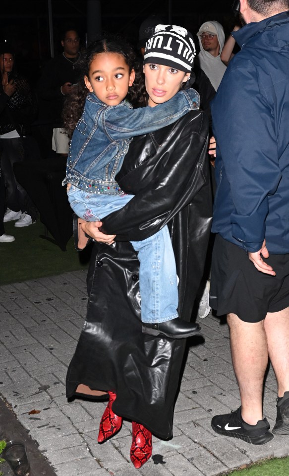 Bianca carrying Kanye and Kim's daughter, Chicago, at the rapper's Vulture album release concert in Miami in December 2023