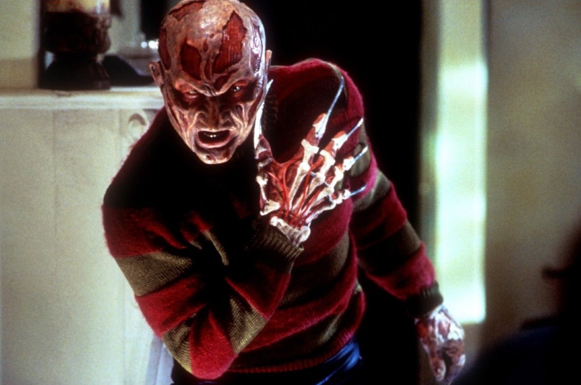 Freddy Kruger holds up his hand menacingly in wes craven's new nightmare