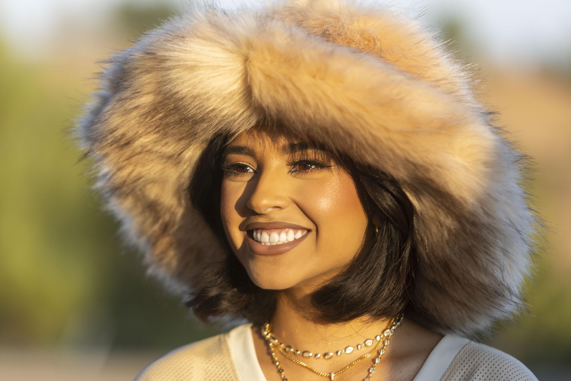 Becky G poses for a photograph wearing a faux fur hat.