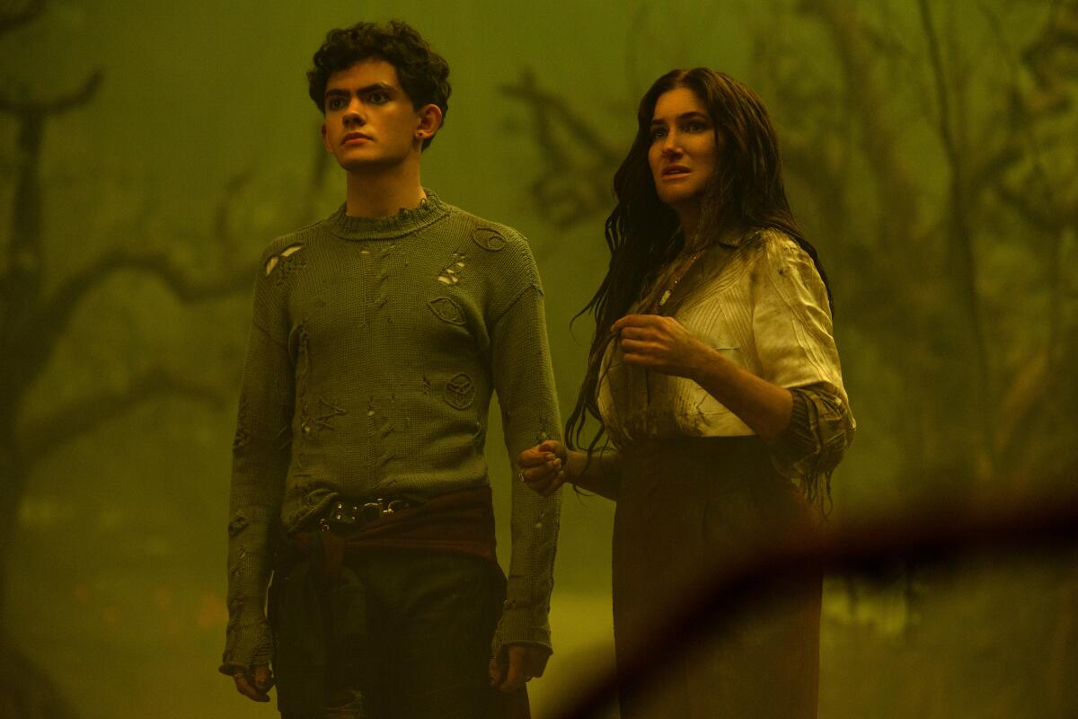 a teenage boy and woman looking a bit disheveled in a foggy forest