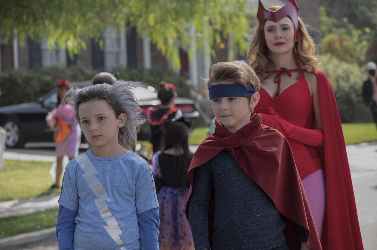 two young brothers and their mother dressed as superheroes for Halloween