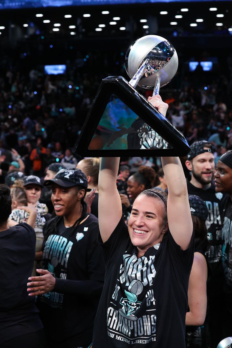  Sabrina Ionescu #20 of the New York Liberty celebrates with the WNBA Championship Trophy after defeating the Minnesota Lynx to win Game Five of the WNBA Finals at Barclays Center on October 20, 2024 in New York City. (Photo by Elsa/Getty Images)