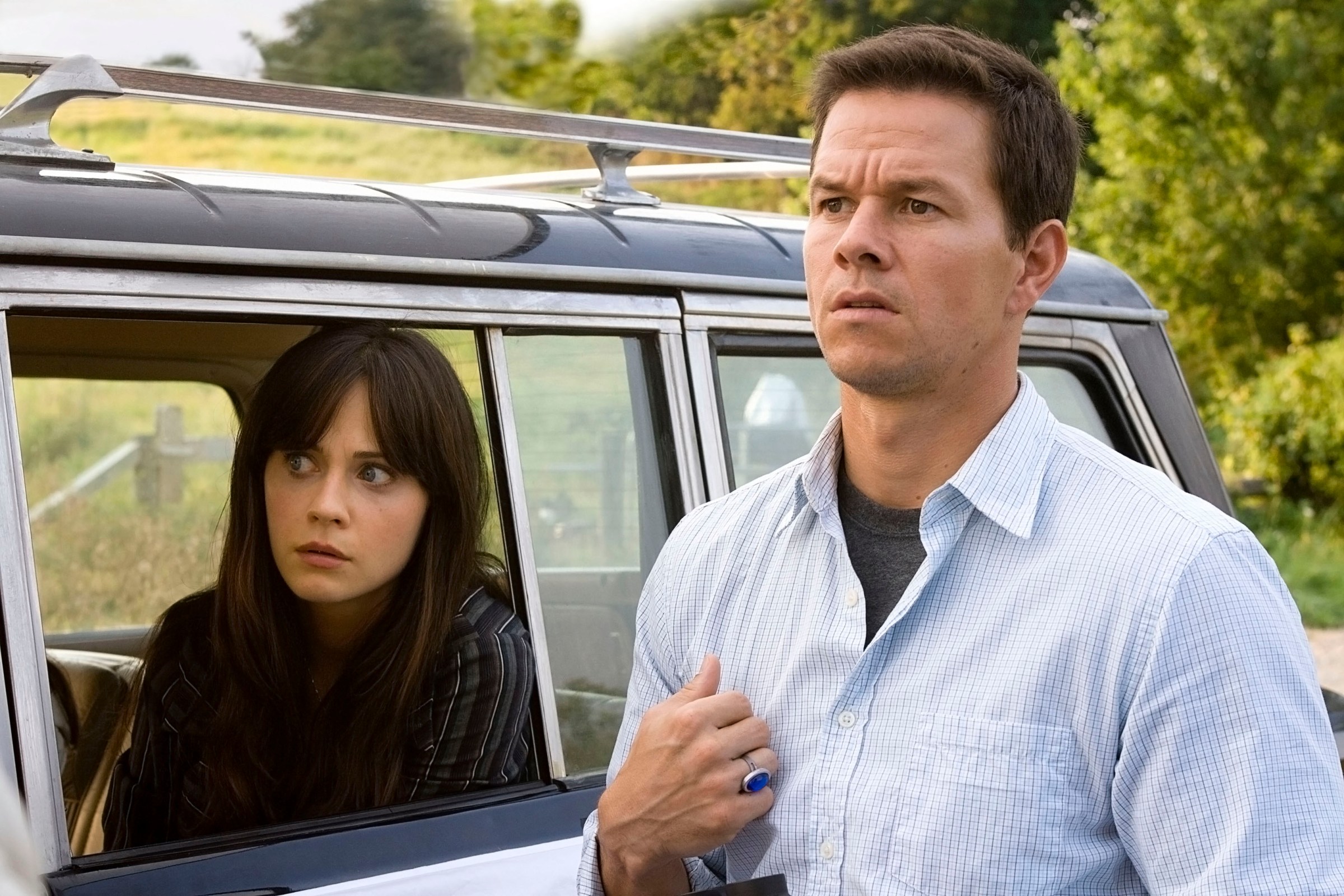 Mark Wahlberg and Zooey Deschanel look toward the camera with concerned looks on their faces in The Happening 