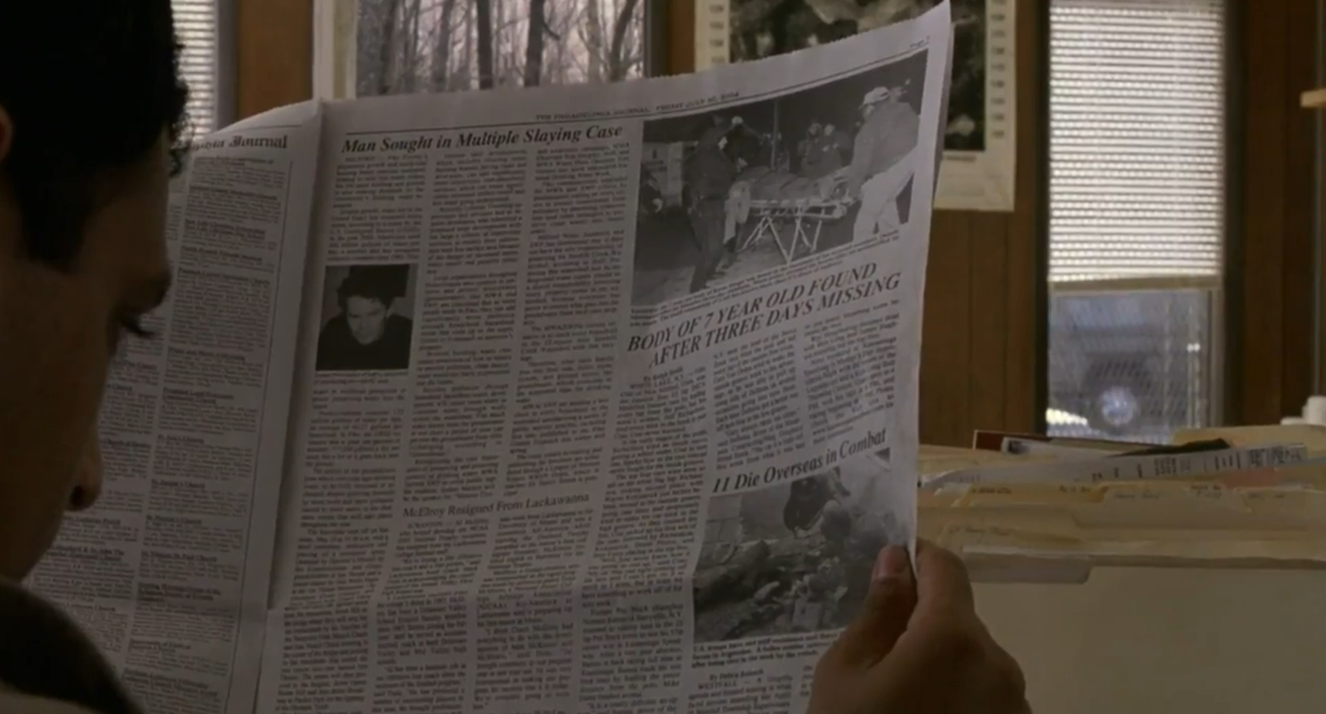 M. Night Shyamalan reading a newspaper in The Village with only the side of his face in frame