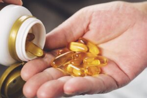 Omega-3 supplements pouring into someone's hand