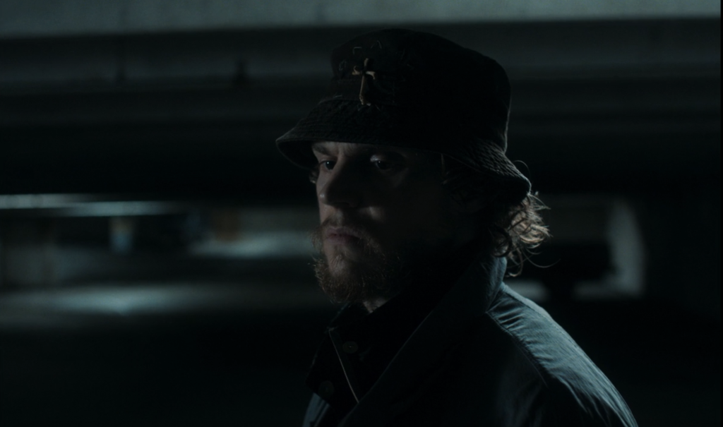 Ralph Bohner (Evan Peters) standing in a dark parking garage looking sad in Agatha All Along