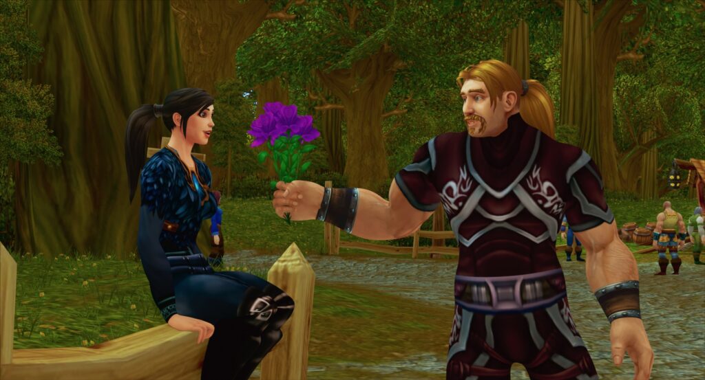 A standing male World of Warcraft  character with a blonde ponytail and mustache offers a bouquet of purple flowers to a female character with a black ponytail who’s sitting on a split-rail fence in a forest in Netflix’s documentary The Remarkable Life of Ibelin