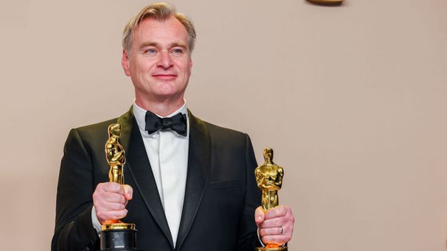 christopher nolan holding two oscar trophies