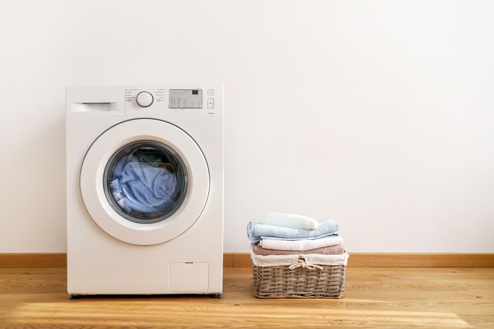 washing machine with laundry basket next to it