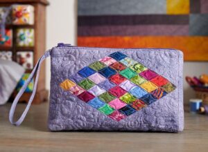 A colorful quilted handbag on a wooden surface