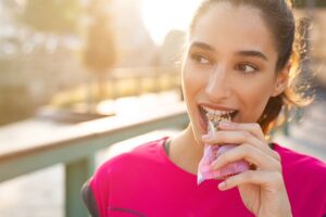 A woman eating a protein bar