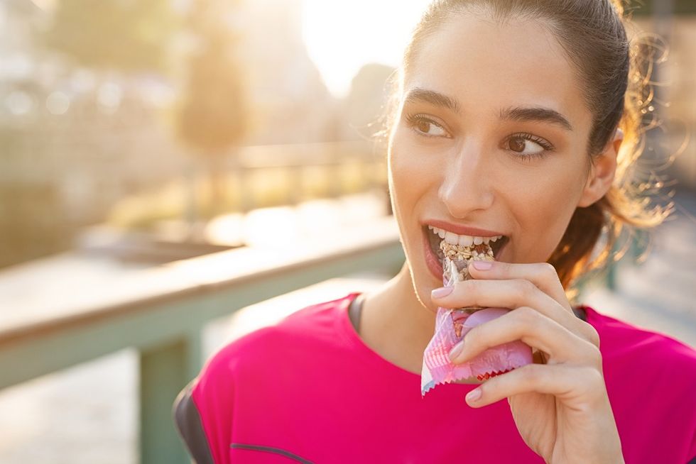 A woman eating a protein bar